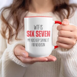 May include: White ceramic mug with a red interior and handle. The mug features the text "WTF IS SIX SEVEN" in black and red, with the phrase "MY KIDS KEEP SAYING IT FOR NO REASON" below. A humorous gift.