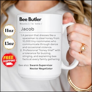 May include: White ceramic mug with a black and white design. The mug features the text "Bee Butler" and a definition of the term. The mug is 11 oz or 15 oz and has free shipping.