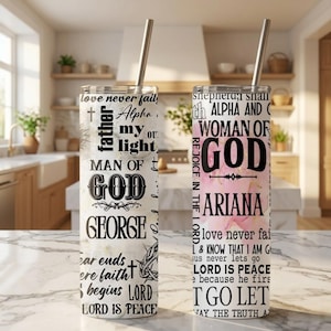 May include: Two stainless steel insulated tumblers with straws. One is white with black text including "MAN OF GOD" and "GEORGE". The other is pink with "WOMAN OF GOD" and "ARIANA". Both have religious quotes.