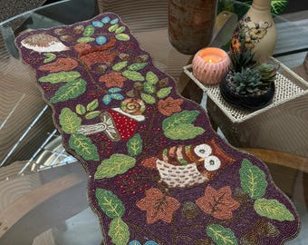 Handgemaakte kleurrijke bloemen tafelloper met geborduurde vlinders, vogels en groene bladeren. Decoratief paars tafelstuk voor in huis.
