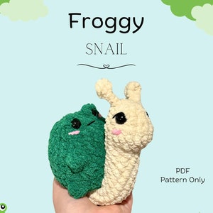 May include: A crochet pattern for a froggy snail amigurumi toy. The pattern is available as a PDF download only. The image shows a completed toy with a green frog on top of a beige snail.
