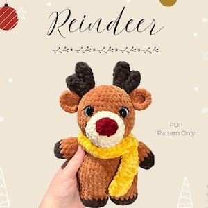 May include: Crochet pattern for a brown and black reindeer with a yellow scarf. The pattern is available as a PDF download only. The image shows the finished crocheted reindeer.