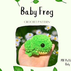 May include: A crochet pattern for a green baby frog amigurumi. The pattern is available as a PDF download only. The image shows a crocheted frog in a hand, with a white background and green leaves.