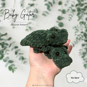 Può includere: Due figure di alligatore all'uncinetto verde scuro con occhi in plastica nera. Il testo Baby Gator Crochet Pattern è visibile nell'angolo in alto a sinistra e il testo No-Sew! è all'interno di una nuvola nell'angolo in basso a destra.