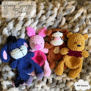 Peut inclure: Quatre peluches crochetées représentant des personnages ressemblant à Bourriquet, Porcinet, Tigrou et Winnie l'ourson, en laine douce. Le texte Honey Snuggle Babies est visible en haut et PDF Pattern en bas.