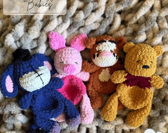 May include: Four crocheted plush toys featuring characters resembling Eeyore, Piglet, Tigger, and Winnie the Pooh, crafted from soft yarn. The text Honey Snuggle Babies is visible at the top, and the text PDF Pattern is at the bottom.