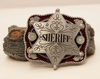 Western belt buckle with a sheriff star on a red shield