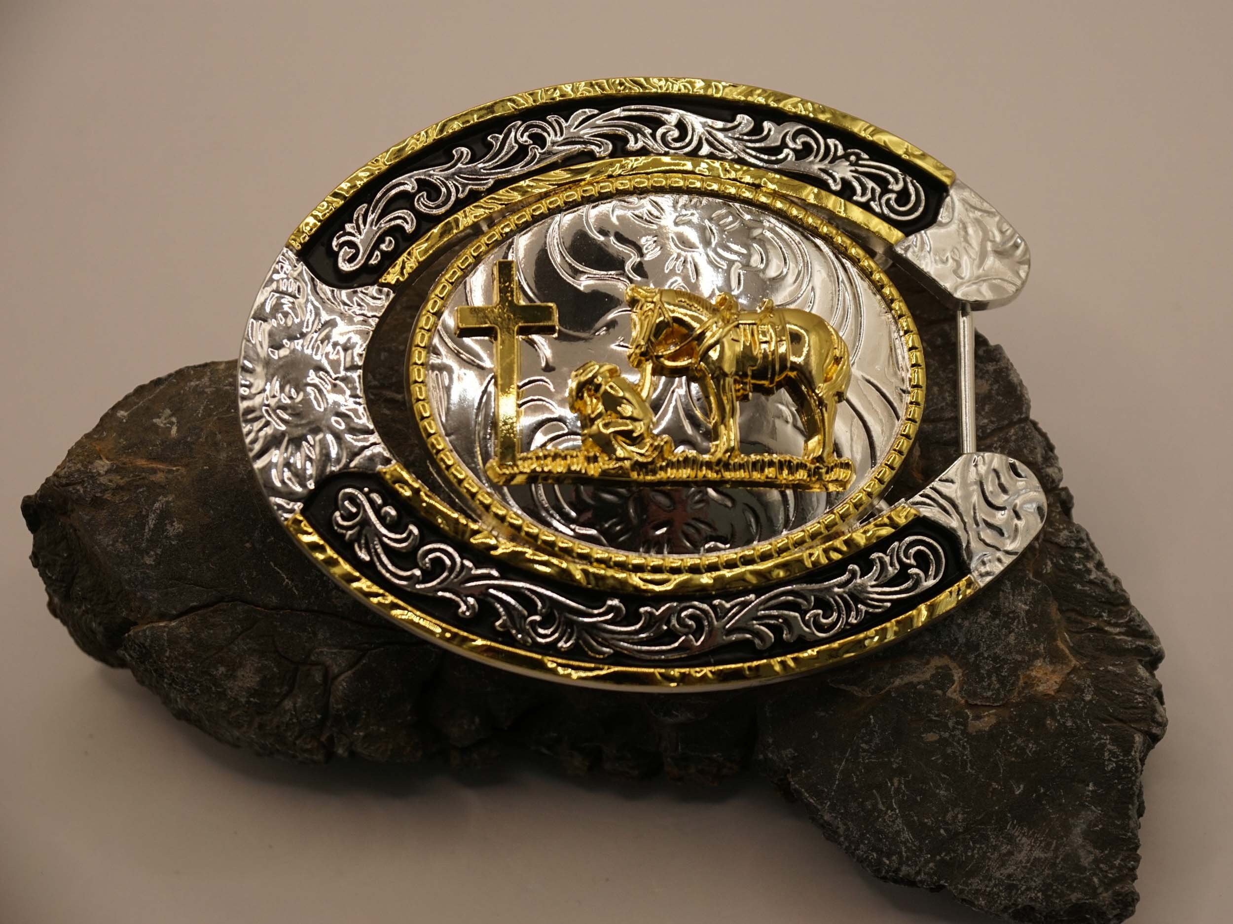 Buckle in horseshoe shape with a praying cowboy at the grave on silver/gold/black shield