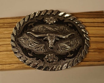 Belt buckle longhorn on decorative shield with flowers and black leather decorative motif