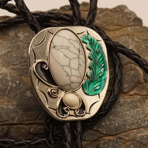 Western bolo tie - lace tie with white stones and a leaf on a nickel-colored shield