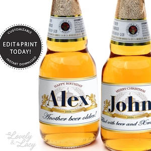 May include: Two beer bottle labels with personalised text. The left label says "Happy Birthday Alex 2026 Another beer older!" The right label says "Merry Christmas John 2026 Filled with beer and Xmas cheer".