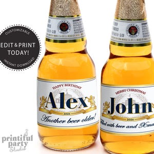 May include: Two beer bottles with custom labels. One says "Happy Birthday Alex 2026 Another beer older!" and the other says "Merry Christmas John 2026 Filled with beer and Xmas cheer!" The bottles have gold foil tops.