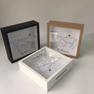 May include: Three shadow boxes in black, white, and natural wood. Each box features a world map outline with a small airplane graphic and the text "My Memories". The boxes have a slot for inserting items.