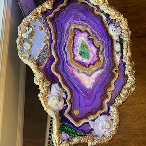 May include: A purple and gold agate resin table top with a swirling pattern and gold leaf accents.