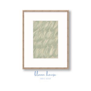 Peut inclure: Une impression encadrée avec un motif abstrait de coups de pinceau vert clair sur un fond beige. L'impression est encadrée dans un passe-partout blanc et un cadre fin de couleur or. Le texte "bloom house PRINT SHOP" est imprimé en bleu en bas.