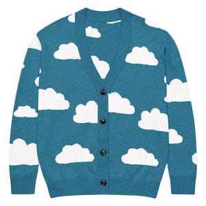 May include: A teal long-sleeve V-neck cardigan sweater featuring a repeating white cloud pattern across the front and sleeves. The garment includes a button-down front closure with four dark buttons aligned vertically along the center placket.