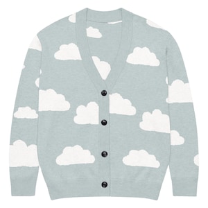May include: A light sage green long-sleeve cardigan featuring a repeating white cloud pattern across the front and sleeves. The garment has a V-neckline, ribbed cuffs and hem, and is fastened down the center with four round black buttons.