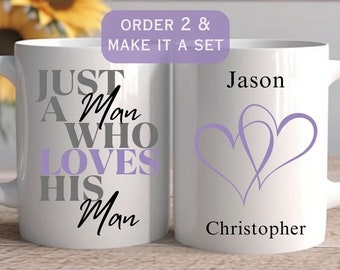 May include: Two white ceramic mugs. One mug has the text "JUST A Man WHO LOVES HIS Man" in gray, black, and lavender. The other mug has two lavender hearts and the names "Jason" and "Christopher".