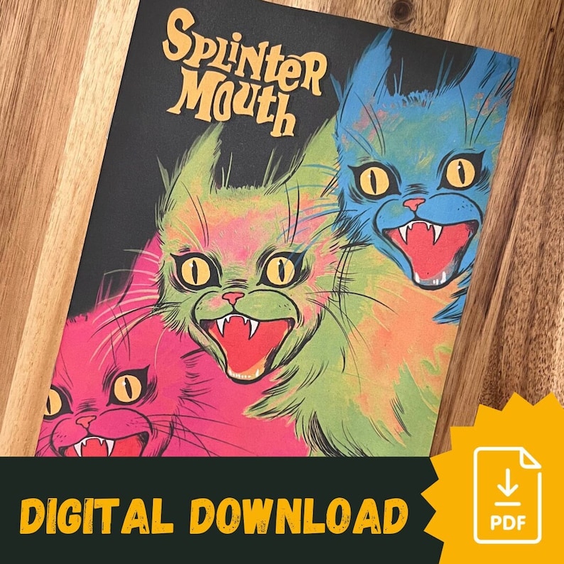 Splintermouth horror zine on a wooden table. There are three feral cats on the cover. A banner at the bottom of the image reads "Digital Download" and shoes an icon of a PDF
