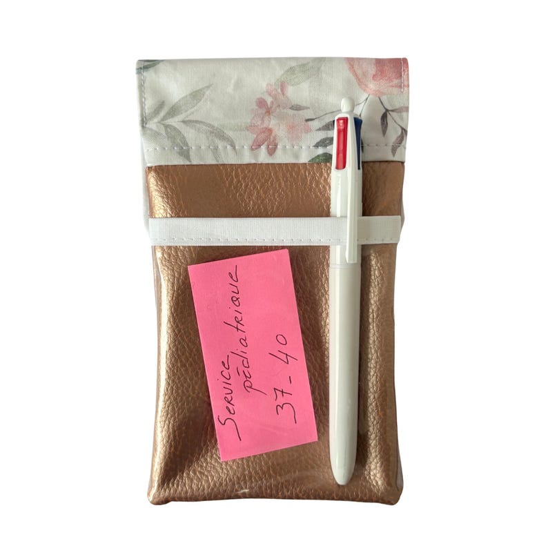 May include: A rose gold leather pouch with a floral print fabric top. A white pen and a pink sticky note with the text "Service P&eacute;dicia Telov&eacute; 37-40" are inside the pouch.