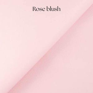 May include: A close-up of a soft, pale pink fabric with a subtle texture. The fabric is called "Rose blush".