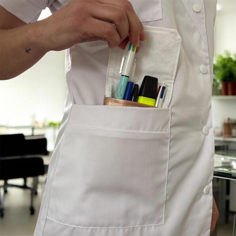 May include: A white lab coat with a large pocket on the front. The pocket is filled with pens and a highlighter.
