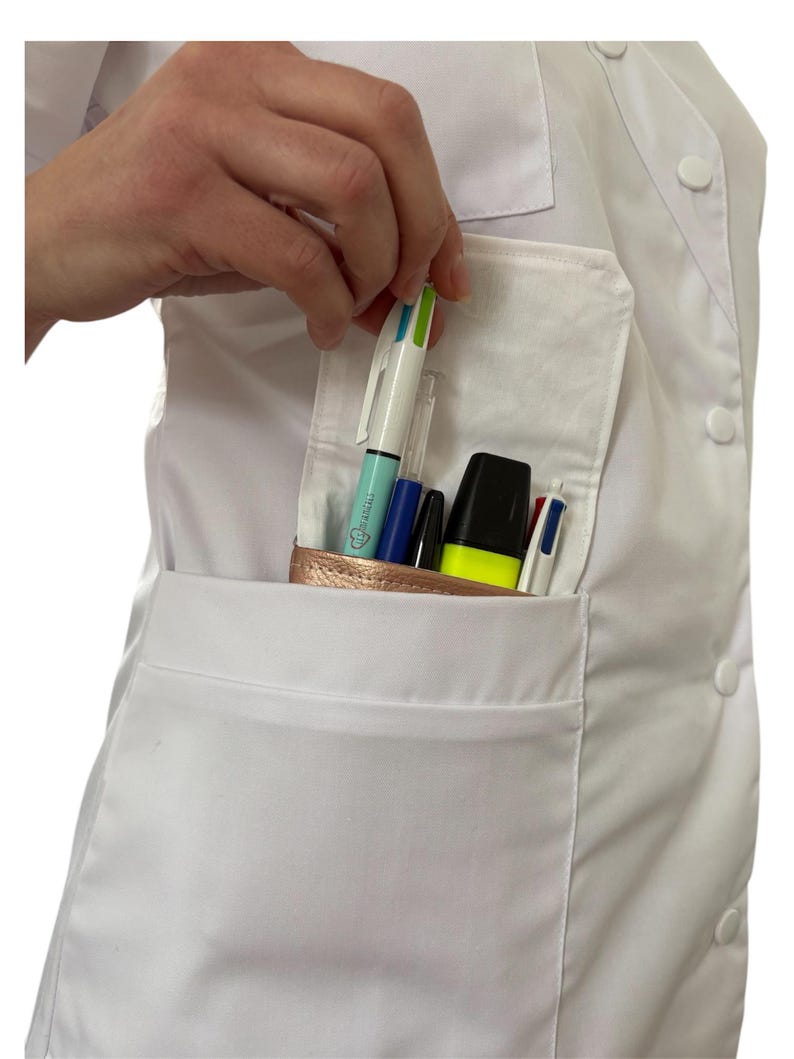 May include: A white lab coat with a large pocket on the left side. The pocket is filled with various pens and a highlighter. The pens are blue, black, green, and white.