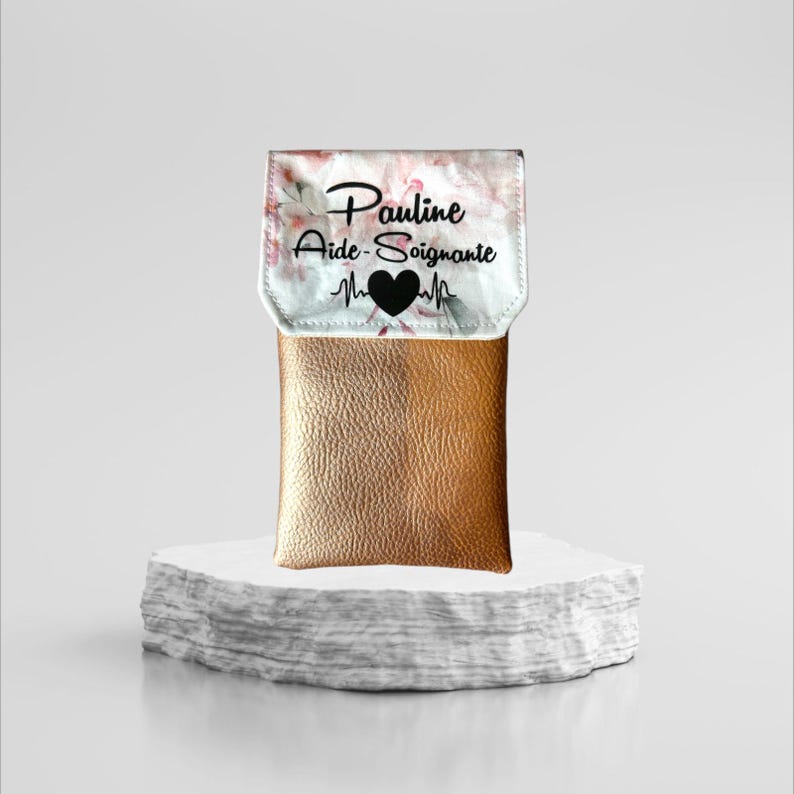May include: A gold phone case with a floral pattern and the text "Pauline Aide-Soignante" with a heart and heartbeat graphic.