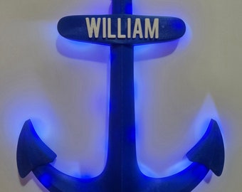 May include: A blue anchor with a white nameplate that reads "WILLIAM" on it. The anchor is illuminated with blue LED lights.