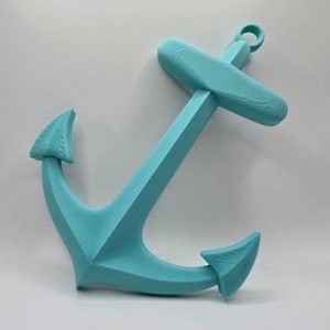 May include: A turquoise blue anchor wall decor. The anchor is made of a smooth, textured material and has a classic design.