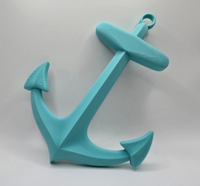 May include: A turquoise blue anchor wall decor. The anchor is made of a smooth, textured material and has a classic design.