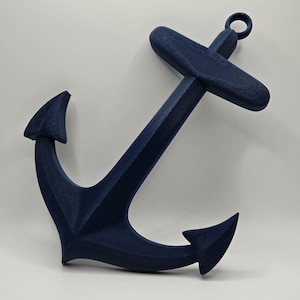 May include: A dark blue anchor made of plastic. The anchor has a loop at the top and two points at the bottom.