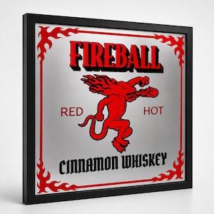 Puede incluir: Un letrero enmarcado con el texto "FIREBALL" en rojo, con un gr&aacute;fico de drag&oacute;n rojo. Las palabras "RED" y "HOT" flanquean al drag&oacute;n, y "CINNAMON WHISKEY" est&aacute; en la parte inferior. El marco es negro.