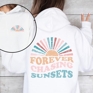 May include: White hoodie with a vintage-style sunset graphic on the back and the text "FOREVER CHASING SUNSETS". A smaller sunset graphic is on the front of the hoodie.