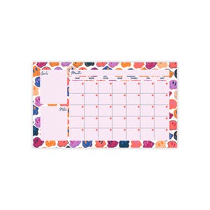 Op de afbeelding: Een roze en witte maandelijkse kalender met een smiley-patroon. De kalender heeft secties voor doelen, notities en een raster voor elke dag van de maand. De dagen van de week zijn gelabeld met Zo, Ma, Di, Wo, Do, Vr, Za.