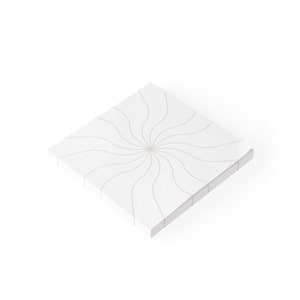 May include: A white square notepad with a grey swirl pattern on the front.