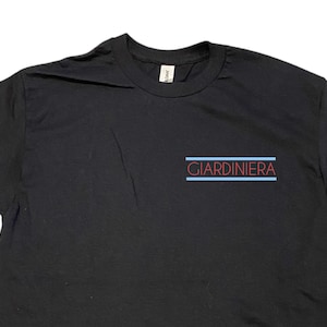 Puede incluir: Camiseta negra con la palabra "GIARDINIERA" impresa en rojo con l&iacute;neas azules arriba y abajo del texto.