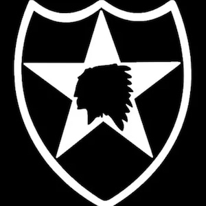 Op de afbeelding: Een wit silhouet van een ster met een profiel van een Amerikaans-Indiaans hoofd erin, alles binnen een witte schildvorm op een zwarte achtergrond.