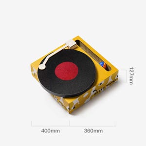May include: A yellow cardboard cat scratcher in the shape of a record player. The black record has a red centre. Dimensions are 40cm x 36cm x 12.7cm. A small ball is visible. The text "KITTY YOYO" is printed on the side.