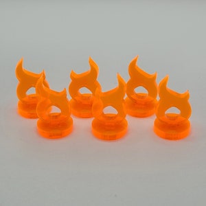 May include: Six orange plastic flame-shaped tokens. The tokens are about 1 inch tall and have a flat base.