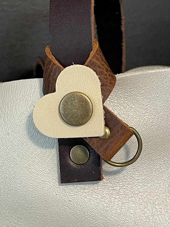 Flair holder to safely attach charms to PLG Portland Leather Goods bags. Made with pebble Brown and Bone full grain leather. Bronze hardware