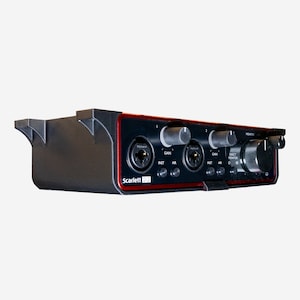 May include: A black and red Focusrite Scarlett 2i2 audio interface with two microphone inputs, two knobs for gain control, and a direct monitor knob.