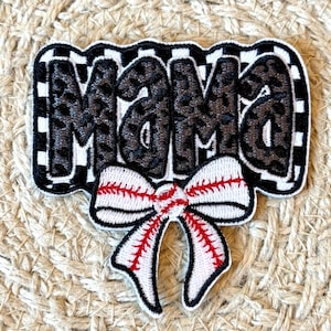 May include: A black and white checkered patch with the word "MAMA" in black with a leopard print design. A white bow with red stitching and a baseball design is attached to the bottom of the patch.