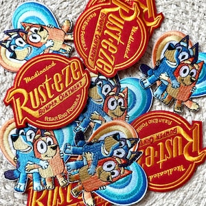 Puede incluir: Una colección de parches bordados con personajes de dibujos animados en azul y naranja. Algunos parches tienen un diseño rojo y amarillo con el texto "Rusteze" y "Bumper Ointment". Los parches son de varias formas y tamaños.