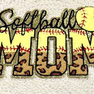 Pode incluir: Patch de glitter dourado "Softball Mom" com uma bola de softball amarela e um design de estampa de leopardo.