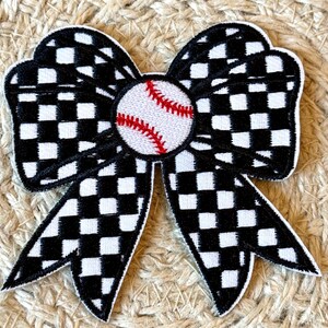 May include: Black and white checked bow with a red stitched baseball in the centre.