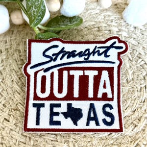 Puede incluir: Parche blanco bordado con detalles rojos y azules. El parche dice "Straight Outta Texas" con un contorno azul del estado de Texas.