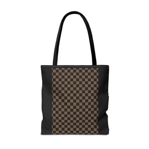 May include: A tote bag featuring a central vertical panel with a brown and black checkerboard pattern. The sides of the bag and the two shoulder straps are solid black. The bag has a rectangular shape and is constructed with a flat base.