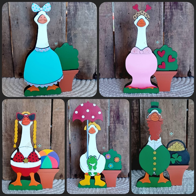 May include: Set of six wooden goose figurines, each with a different theme and outfit. The geese are painted in various colors, including blue, pink, red, green, and white. Each goose is holding a different accessory, such as an umbrella, a beach ball, a pot of gold, a frog, and a heart-shaped bush.
