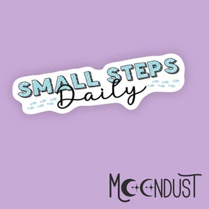 May include: A white sticker with the text "SMALL STEPS Daily" in a blue and black design. The sticker has a light blue background and a trail of footprints. The Moondust logo is at the bottom.